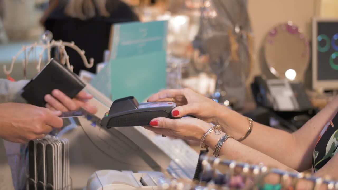 A customer using a payment terminal at a store counter